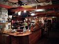 The counter of The Alley Cat with coffee, tea, and painted ceiling tiles.